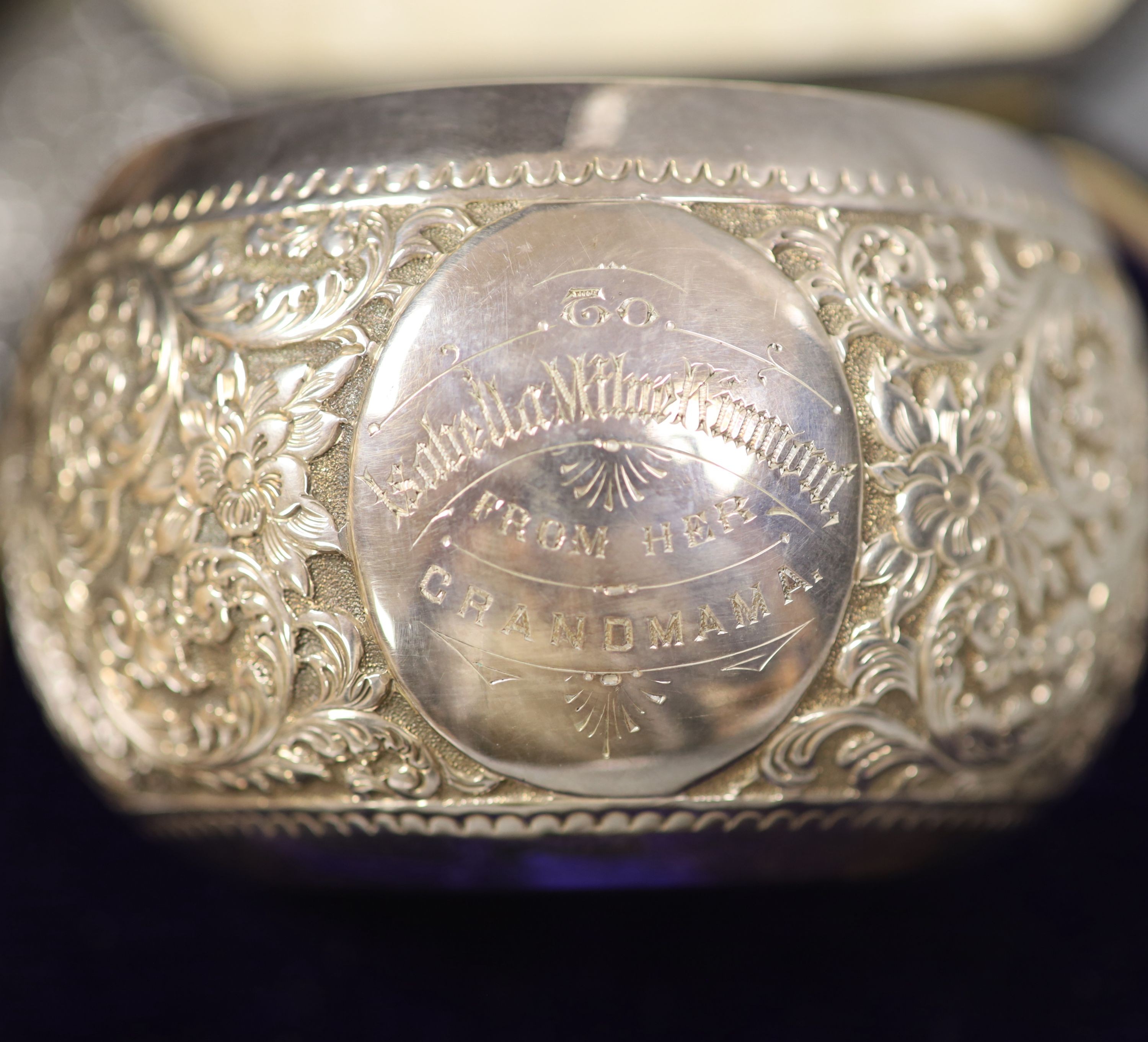 A Victorian cased matched embossed silver christening trio, comprising , bowl, napkin ring and fork, bowl, Sheffield, 1889, 10.3cm, 5.5oz.